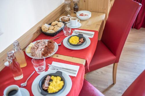 a table with plates of food on a red table cloth at Agriturismo Al Maniero in Trento