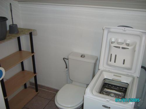 La petite salle de bains est pourvue de toilettes et d'un réfrigérateur. dans l'établissement CHEZ MARTINE Appt climatisé 1 Chambre, à Capbreton