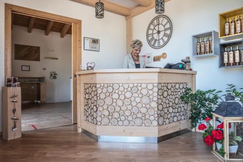 a woman standing behind a counter in a room at Agriturismo Al Maniero in Trento