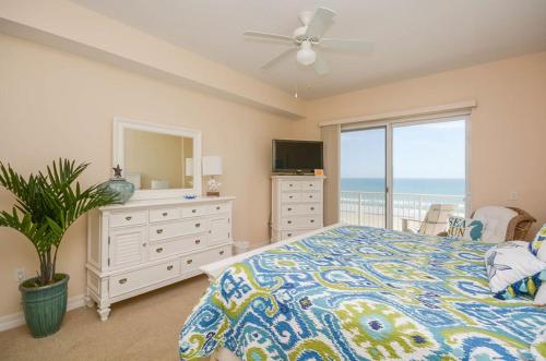 a bedroom with a bed and a dresser with a mirror at Malibu 501 by Ocean Properties in New Smyrna Beach