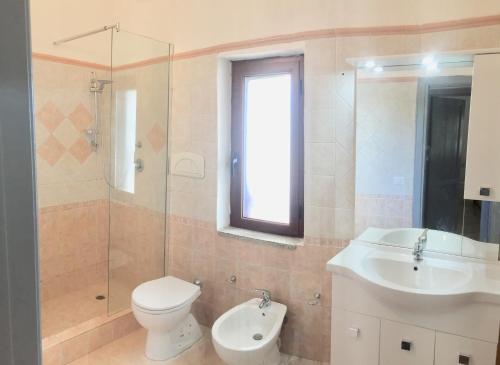 a bathroom with a toilet and a sink and a shower at International House San Teodoro in San Teodoro