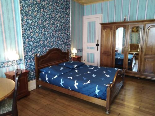 a bedroom with a bed with a blue blanket with birds on it at Le Point du Jour in Revin