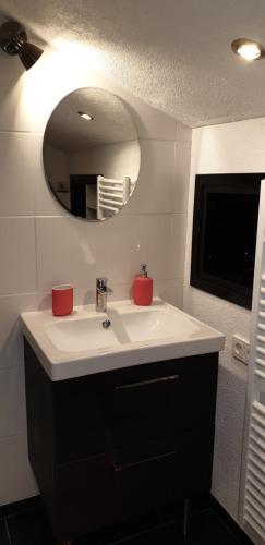 bagno con lavandino bianco e specchio di Haus Monteiro a Elbigenalp