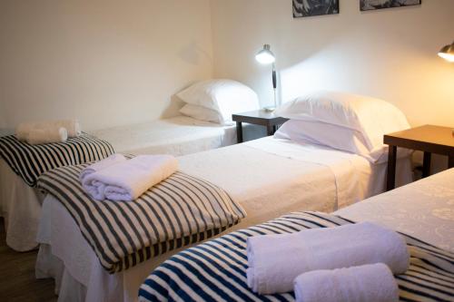 
a hotel room with two beds and two nightstands at BA STOP Hostel in Buenos Aires
