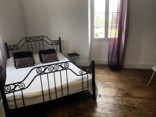 a bedroom with a black and white bed and a window at Au Plech in Mont-dʼAstarac