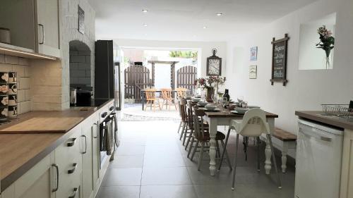 a kitchen with a long table and a dining room at Snowdon Retreat Villa by Seaside Llandudno in Llandudno