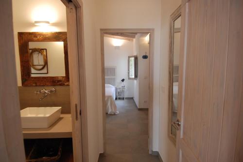 a hallway with a bathroom with a sink and a mirror at La Hacienda in San Ferrán de ses Roques