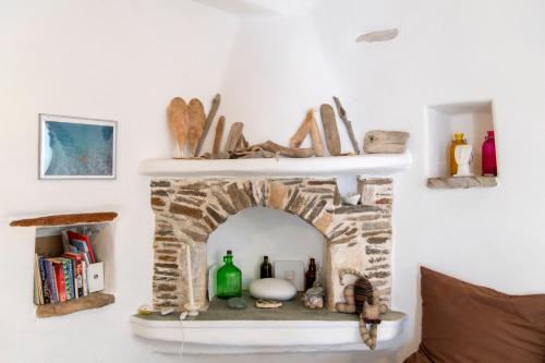 a stone fireplace with a shelf on a wall at Traditional stonebuilt house in Kampos Paros