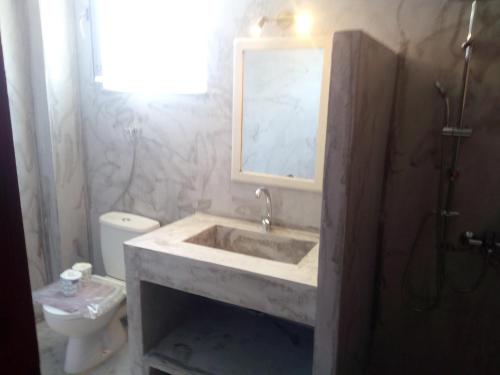 a bathroom with a sink and a toilet at ThalaSEA Apartments in Chrani