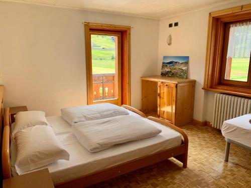 sypialnia z 2 łóżkami i oknem w obiekcie Casa Susanna w Livigno