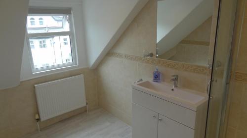 Un baño con lavabo y ventana. en Snowdon Retreat Villa by Seaside Llandudno, en Llandudno