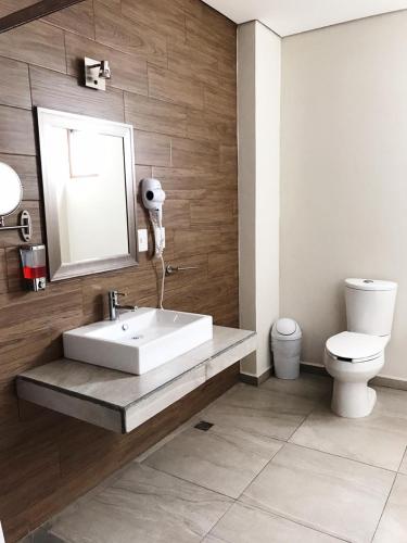 a bathroom with a sink and a toilet at Hotel Guivá Aeropuerto in Oaxaca City