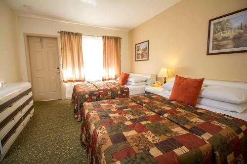 een hotelkamer met 2 bedden en een bank bij Parkway Inn in Miami