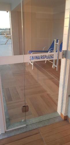 a glass door with a bed in a room at Apart-Hotel Golden Lake 2 in Arraial do Cabo