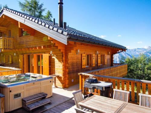 eine Blockhütte mit einem Tisch und einem Grill auf einer Terrasse in der Unterkunft Nice Holiday Home in Riddes with Sauna in La Tzoumaz
