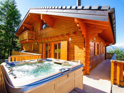 einen großen Whirlpool im Hinterhof einer Blockhütte in der Unterkunft Nice Holiday Home in Riddes with Sauna in La Tzoumaz