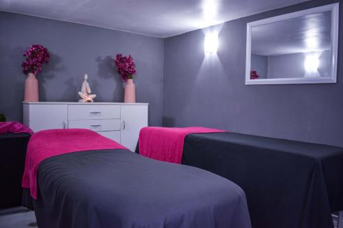 a bedroom with two beds and a mirror at Santorini Guesthouse in Amanzimtoti
