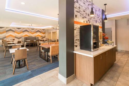 a restaurant with tables and chairs and a tv on a wall at La Quinta by Wyndham Las Vegas Airport South in Las Vegas