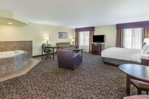 a hotel room with a bed and a tub and a bedroom at La Quinta by Wyndham Las Vegas Airport South in Las Vegas