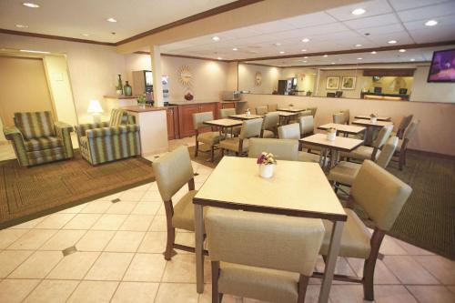 Un comedor con mesas y sillas en un restaurante. en La Quinta Inn by Wyndham Milwaukee Airport / Oak Creek, en Oak Creek