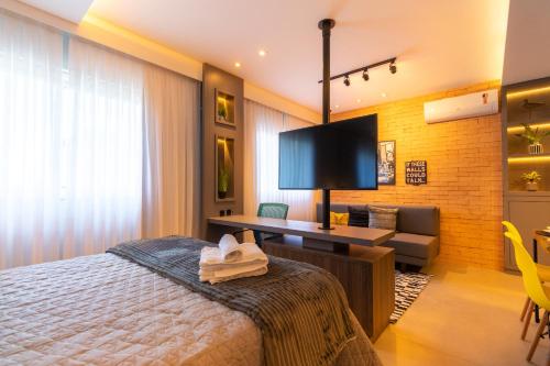 a bedroom with a bed and a desk and a chair at Luxuoso Apto Em Frente Ao Shopping Curitiba - Piscina, Academia e Sauna in Curitiba