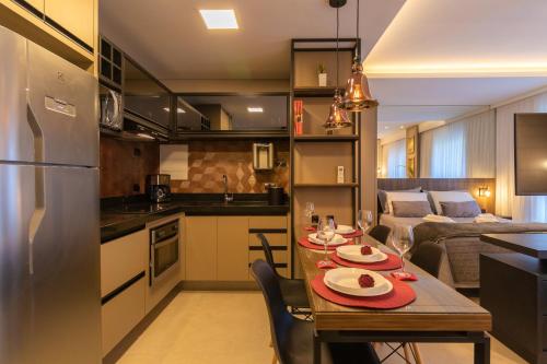 a kitchen and living room with a table and chairs at Luxuoso Apto Em Frente Ao Shopping Curitiba - Piscina, Academia e Sauna in Curitiba