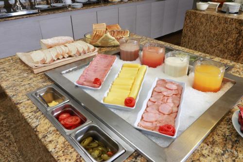 Un buffet con diferentes tipos de comida en un mostrador. en Holiday Inn Mexico City - Trade Center by IHG, en Ciudad de México