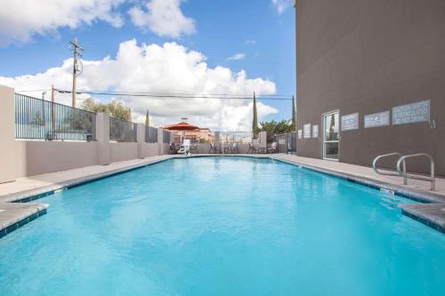 a large blue swimming pool in a building at La Quinta by Wyndham Madera in Madera