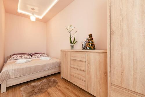 a bedroom with a bed and a wooden dresser at Piast Apartament in Kraków