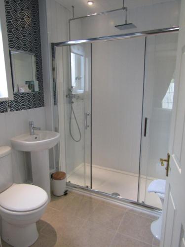 uma casa de banho com um chuveiro, um WC e um lavatório. em Lindfields em Inverness