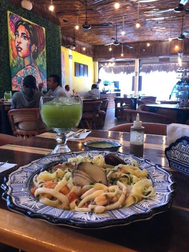 a plate of food on a table with a drink at Hotel Casa de las Flores in Playa del Carmen