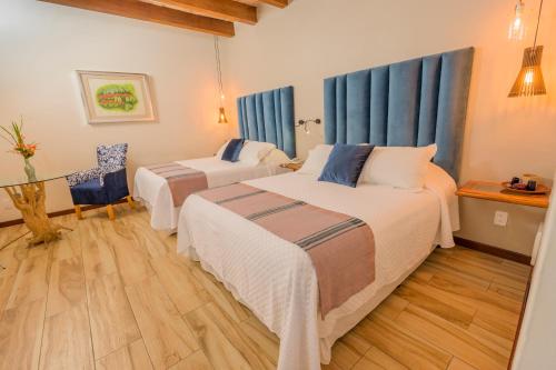 a hotel room with two beds and a table at Hotel Casa Vertiz in Oaxaca City