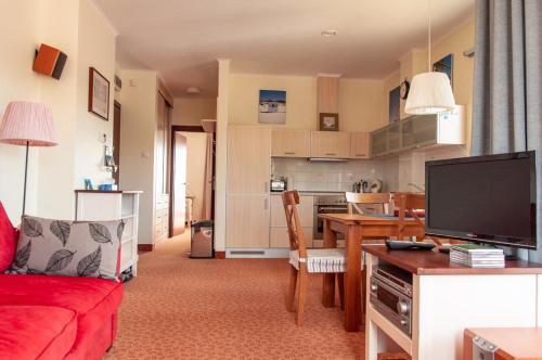 哈烏彼的住宿－Villa Baltic 14 Chałupy，一间带红色沙发的客厅和一间厨房