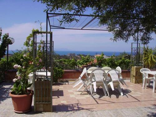 a group of white chairs and tables on a patio at La casa di Mariù in Furnari
