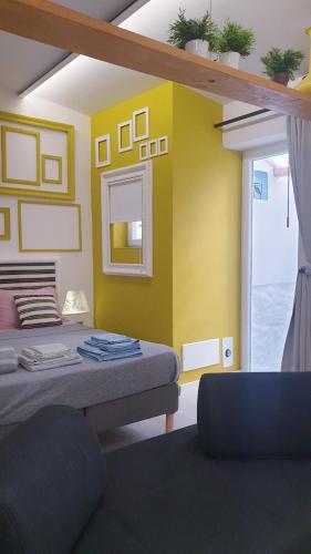 a room with a bed and a yellow wall at Mediterraneo House in Palermo