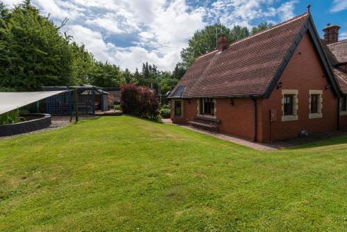 a house with a large yard next to a building at Finest Retreats - The Grove Annexe in Craven Arms