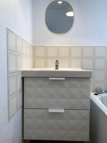 a bathroom with a sink and a mirror and a tub at Chez Edwige à Cabourg thalasso plage WIFI in Cabourg