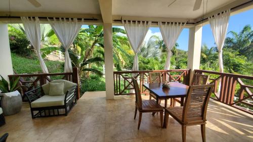 a room with a table and chairs on a balcony at Villa Touloulou in English Harbour Town