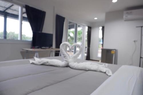 a bed with two white animal decorations on it at Baantia Chomtawan in Surat Thani