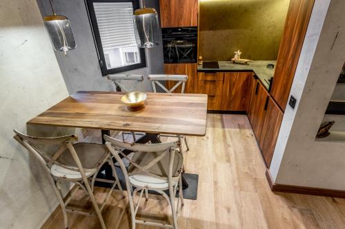a kitchen with a wooden table and stools at Bella Roe Premium Apartments in Belgrade