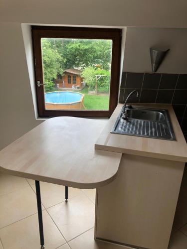 a kitchen counter with a sink and a window at HOME SWEET HOME in the green lung of Brussels in Hoeilaart