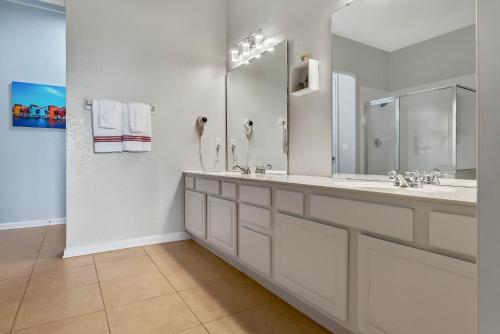 a bathroom with two sinks and a large mirror at Vista Cay in Orlando