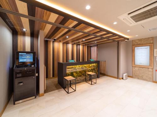 a large room with a fish tank and a tv at Super Hotel Iyo Saijo in Saijo
