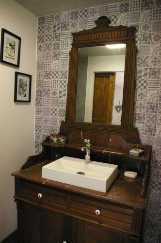 a bathroom with a sink and a mirror at Au charme d'antan in Féron