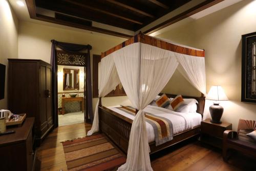 a bedroom with a canopy bed in a room at Amata Lanna Village อมตะล้านนาวิลเลจ in Chiang Mai