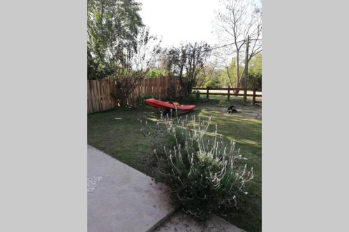 a garden with a red kayak in the yard at ROSALIMON in Nueva Palmira