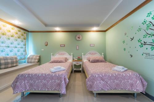 a room with two beds and a couch at The Lilly Hotel in Chiang Mai