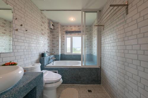 een badkamer met een bad, een toilet en een wastafel bij The Lilly Hotel in Chiang Mai