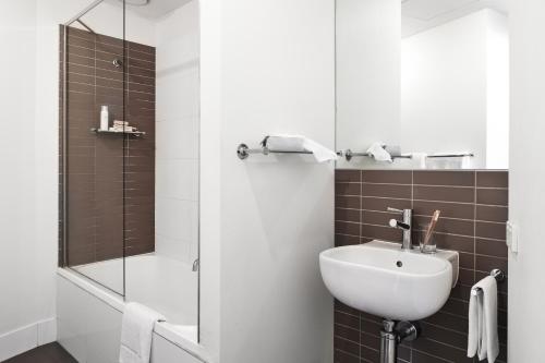 a bathroom with a white sink and a shower at Punthill Knox in Wantirna South