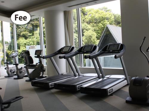 a row of treadmills in a gym with a window at Grand Prince Hotel Hiroshima in Hiroshima